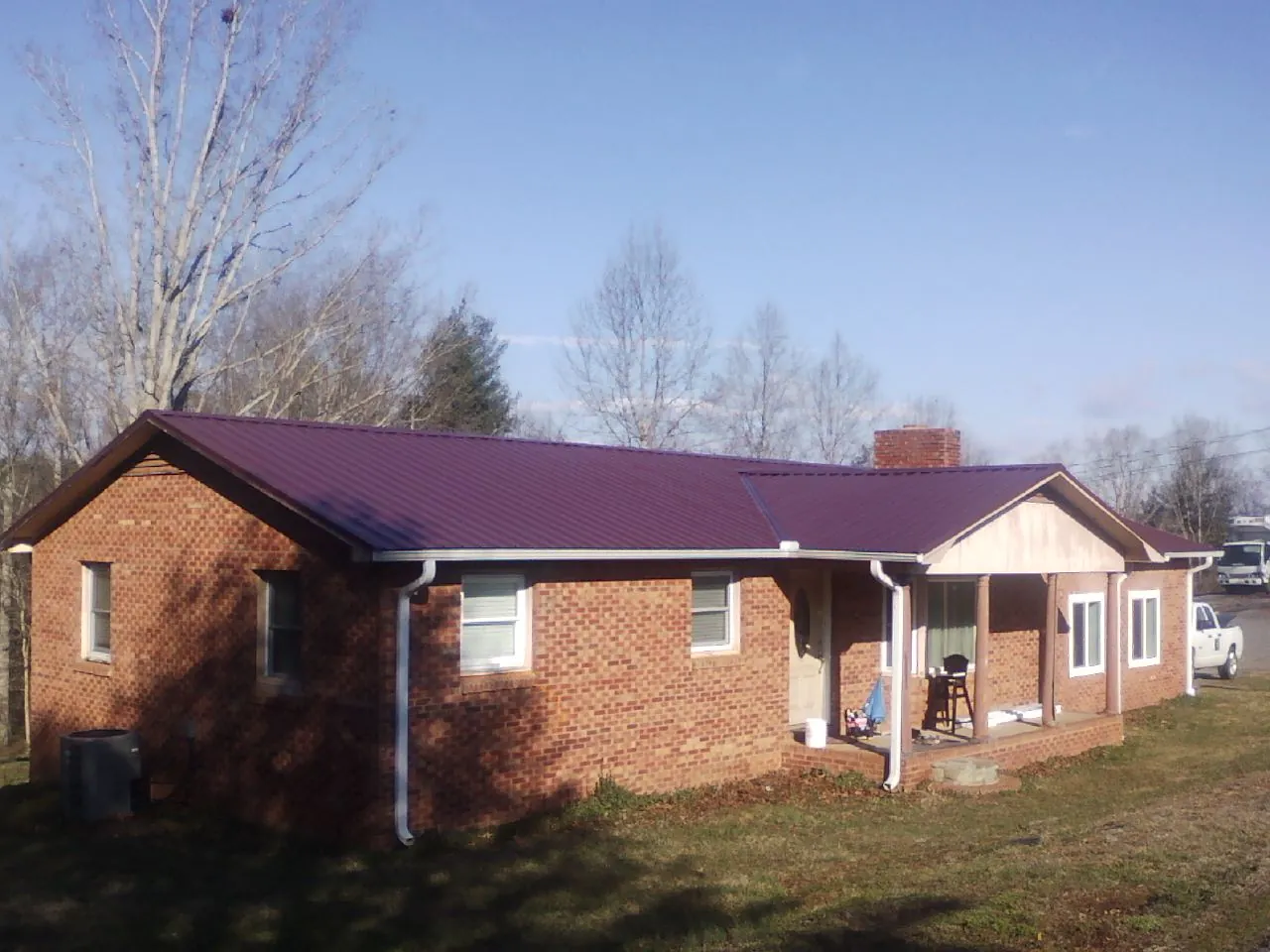Burgundy metal roof on a brick ranch home with a new addition in Union