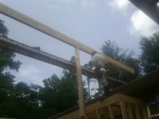 Carpenter setting a ridge beam over a new addition frame — Ice Dam Removal by Roofing Brothers in Union